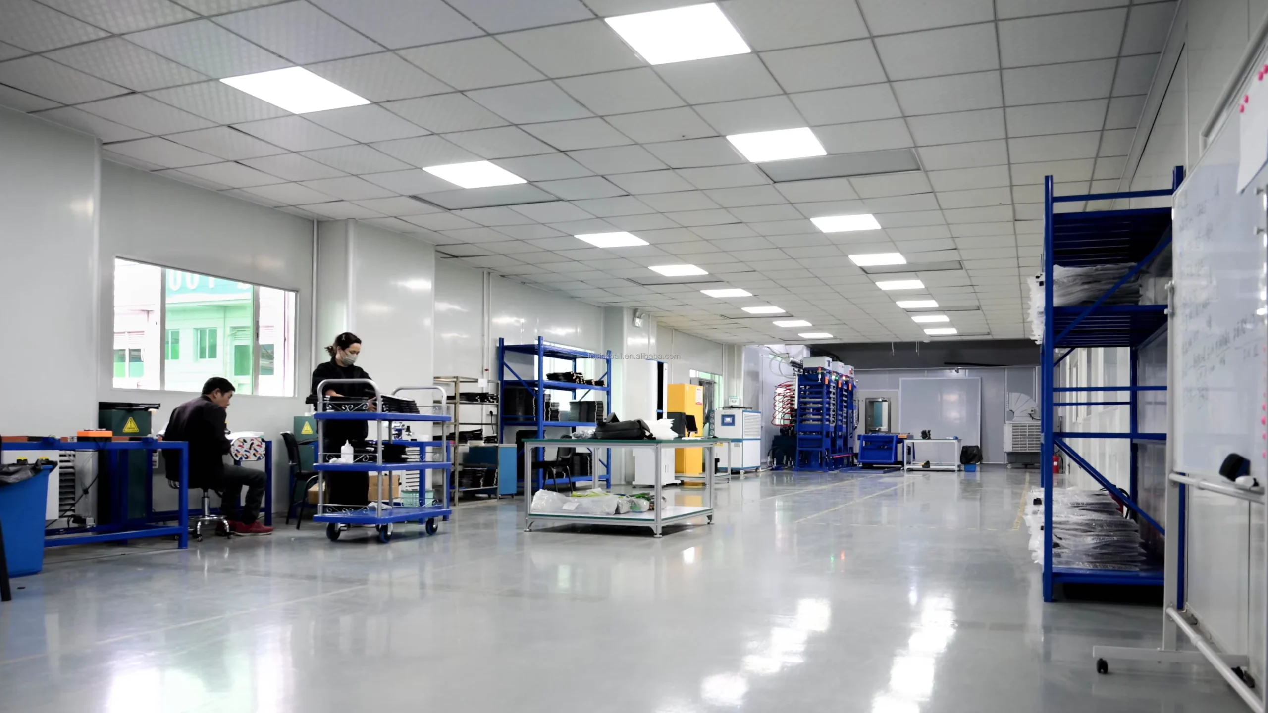 Paddle production workshop with assembly benches, storage racks and presses in the background