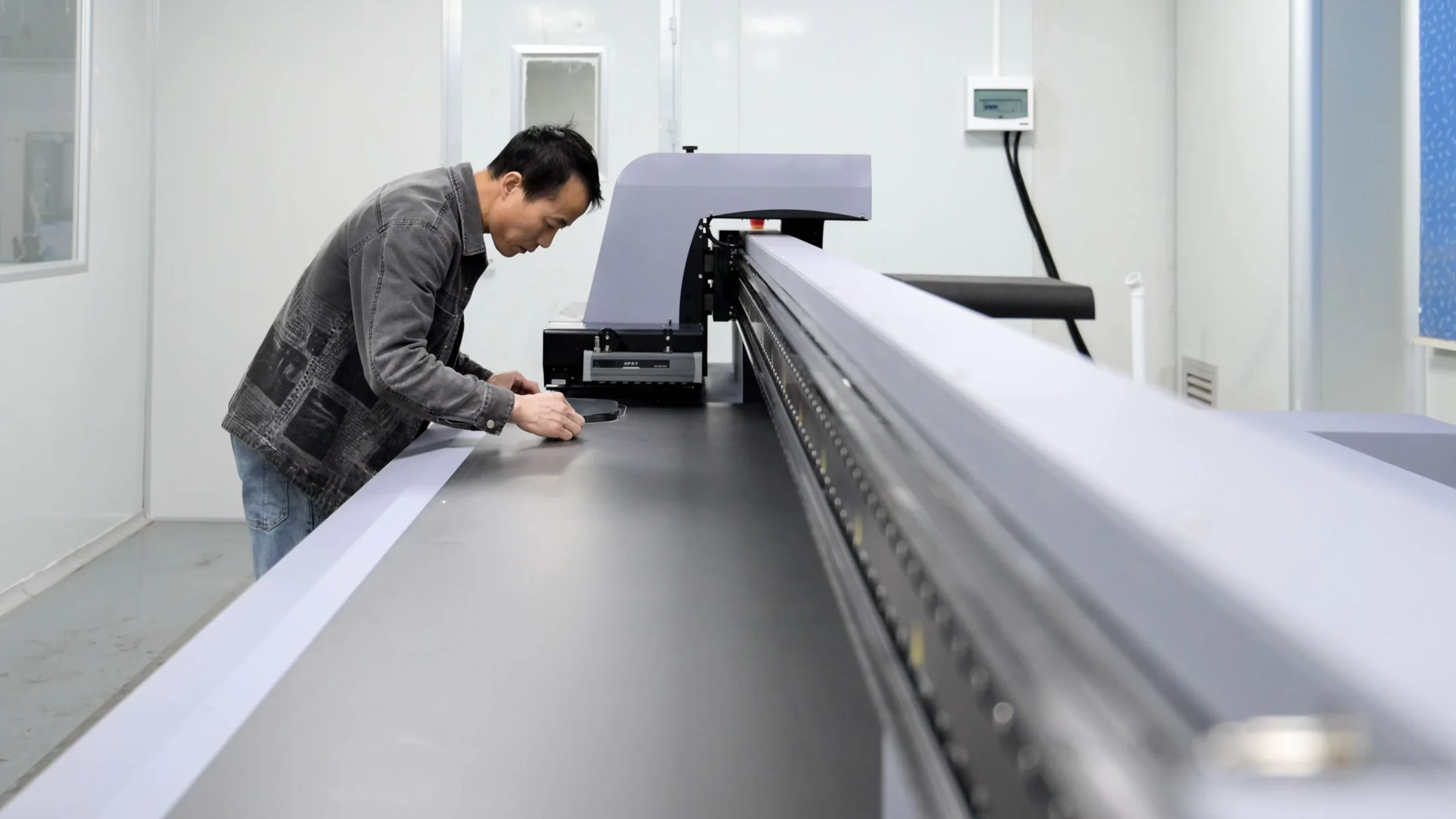 Operator positioning a print sheet on a flatbed printer